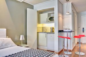 a bedroom with a bed and two red stools at Regency Golf - Hotel Urbano in Montevideo