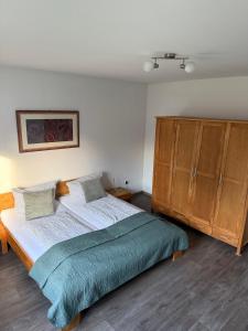 a bedroom with a large bed and wooden cabinets at Ferienwohnungen Avenor in Norden