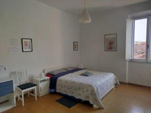 a bedroom with a bed and a chair and a window at Treehouse - Spacious Private Rooms in Central Pisa Near Station & Airport in Pisa