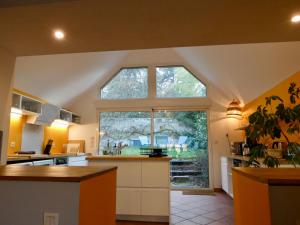a large kitchen with a large window in a room at Moulin XVe siècle - Gîte privatif 8 pers - Rivière - Châteaux de la Loire in Vineuil
