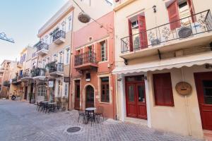 a street with tables and chairs on a cobblestone street at Alegria Pension in Chania