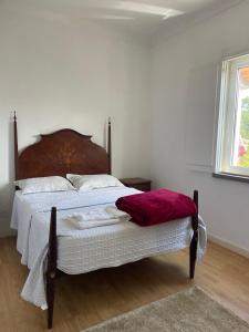 a bedroom with a bed with a red blanket on it at Casa do Pinhal in Moledo