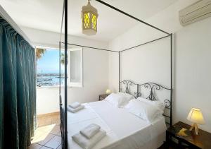 a bedroom with a canopy bed with a view of the ocean at Solemar Sicilia - Palazzo Eos e Aura in Porticello