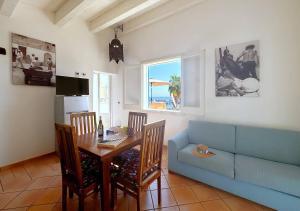 a living room with a table and a blue couch at Solemar Sicilia - Palazzo Eos e Aura in Porticello