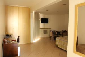 a room with a bed and a table with a television at Actuall Convention Hotel in Contagem