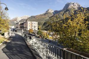 a bridge over a road with mountains in the background at Plavna Apartment in Scuol