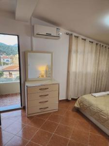 a bedroom with a dresser with a mirror and a bed at Apartment 3 by Villa Ceni in Elbasan