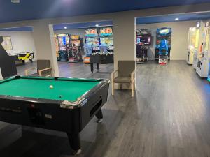 a room with a pool table and several video games at Woodwards White Mountain Resort, BW Signature Collection in Lincoln