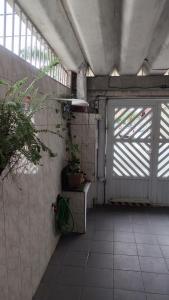 a garage with a door and plants in it at Casa Amarelinha da Tupi in Praia Grande
