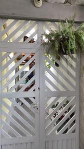 a white garage door with a plant on it at Casa Amarelinha da Tupi in Praia Grande