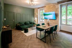 a living room with a green couch and a table at Charmant appartement - L'émeraude in Fontenay-le-Comte