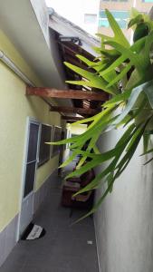a hallway in a building with a ceiling with a plant at Casa Amarelinha da Tupi in Praia Grande +25 photos