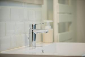 a bathroom sink with a silver faucet on it at Cityscape in Arras +26 photos