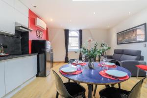 a kitchen and dining room with a blue table and chairs at Cityscape in Arras