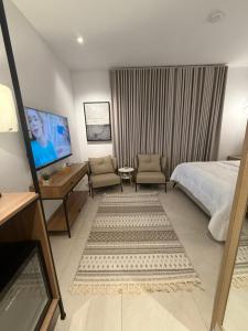 a hotel room with a bed and a desk and chair at نزل عطيف - وصول ذاتي in Al Kharābah