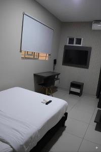 a bedroom with a bed and a desk and a screen at Hotel Doral Inn in Ibagué