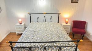 a bedroom with a bed and a red chair at La Souste appartement avec jardin privatif in La Fare-en-Champsaur