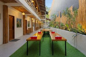 a corridor with tables and plants in a building at Islanders Hostel Siquijor in San Juan