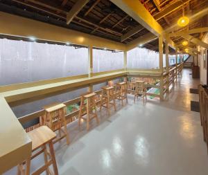 a bar with wooden chairs and tables in a room at Islanders Hostel Siquijor in San Juan