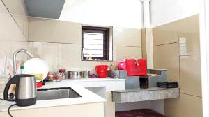 a kitchen with a sink and red appliances in it at Couples Nest in Kottakamboor