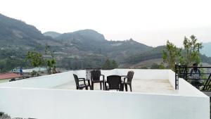a group of chairs sitting on a balcony with mountains at Couples Nest in Kottakamboor