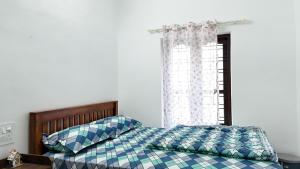 a bedroom with a bed and a window at Couples Nest in Kottakamboor