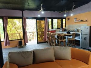 a living room with a couch and a kitchen at ISA BELLA Hospedaje y Cabaña Entre Aves in Luna Park