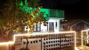 a house with lights in front of a fence at Couples Nest in Kottakamboor +18 photos