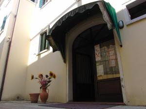 an entrance to a building with a vase with flowers in it at Locanda Alla Stazione in Marano