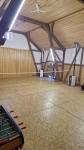 a large room with a wooden ceiling and a tennis court at Gîte Le Charme in Aspach-le-Bas