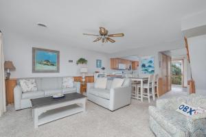a living room with a couch and a ceiling fan at 4209 - Moby Duck in Duck