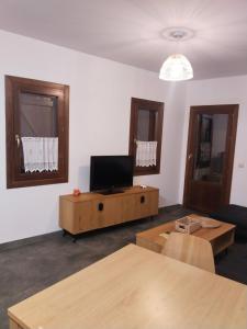a living room with a tv and a table at FIGONERO 4-6 in Las Peñas de Riglos