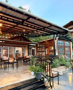 a restaurant with wooden tables and chairs and windows at Jambayang Resort in Thimphu