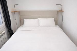 a white bed with two pillows in a room at Mountain getaway in Saint-Chaffrey in Saint-Chaffrey