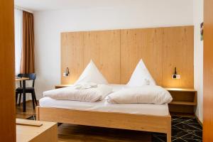 a bedroom with a large bed with white pillows at Braustüble und Hotel zur Post in Weiler-Simmerberg