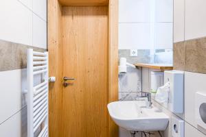 a bathroom with a sink and a wooden door at Braustüble und Hotel zur Post in Weiler-Simmerberg