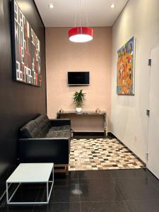 a living room with a couch and a table at Hotel Urbis a 10 minutos Rua 25 de Março, Brás,Bom Retiro,a 2 minutos do Mirante Sampa Sky in São Paulo