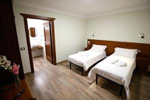 a bedroom with two beds with white sheets at Casale Sienti'n Può in Norcia