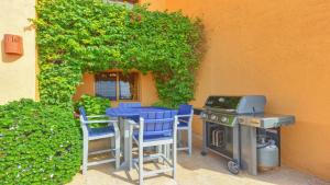 a patio with a table and chairs and a grill at Ground Floor 2BR Beachfront - Steps to Pool - Princesa E104 - BeachBumCondos in Puerto Peñasco