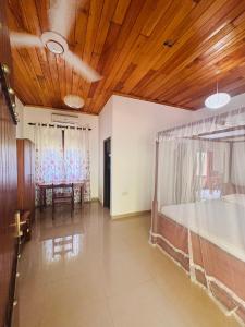 a room with a bed and a wooden ceiling at Hiru Villa in Bentota