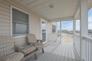 a porch with a rocking chair and a window at 5061 - Good Night Irene in Kill Devil Hills