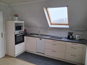 a kitchen with a sink and a stove and a window at Ferienwohnung Luise Blum in Steffeln