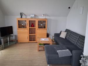a living room with a couch and a entertainment center at Ferienwohnung Luise Blum in Steffeln