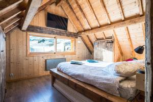 a bedroom of a wooden cabin with a bed in it at Chalet Liloo sous la neige in Saint-Sorlin-dʼArves