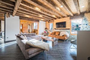 a living room with two couches and a tv at Chalet Liloo sous la neige in Saint-Sorlin-dʼArves