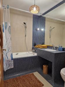 a bathroom with a tub and a sink and a toilet at Omah Jawa in Lourdes