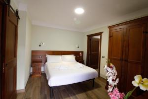 a bedroom with a white bed and wooden cabinets at Casale Sienti'n Può in Norcia
