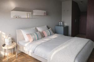 a bedroom with a large white bed with pillows at Sea-Me Ostend in Ostend