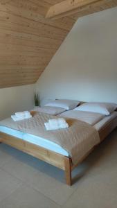 two beds in a room with a wooden ceiling at Apartments Ela in Rateče