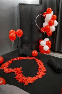 a table with red and white balloons and a cake at Suite CinéRoom à 25 min de Paris in Franconville